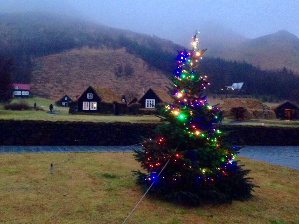 Historical turfhouses with illuminated Christmas tree at Skogar Museum. 03.12.2016